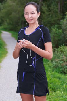 Fit young jogger adjusting the music on her mp3