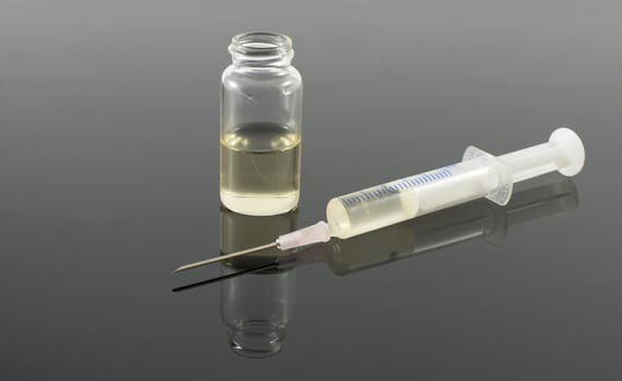 injection needle with bottle on dark background