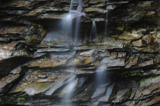 The fresh mountain water plays with a rock
