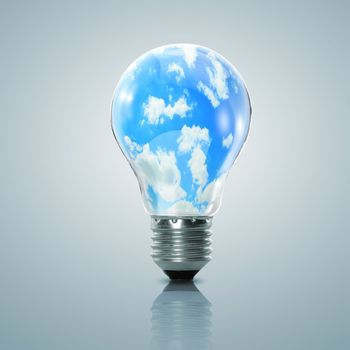 Electric light bulb and blue sky with clouds inside it