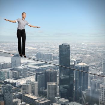 Business woman balancing high over a cityscape