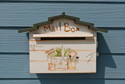 Small white mailbox on blue wooden background, can be use for communication related concept designs.