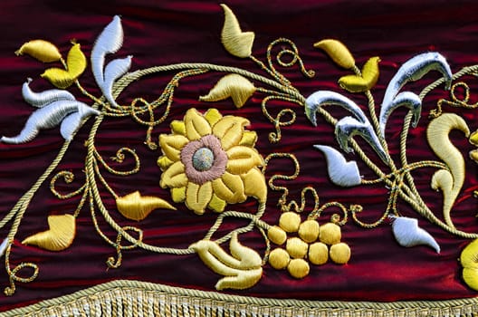 Embroidered flower on red suede cloth