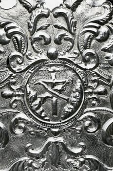 Detail of an old hammered aluminum religious art 