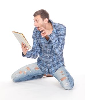 Casual mature man in ragged jeans kneeling barefoot on the floor, communicates via tablet pad