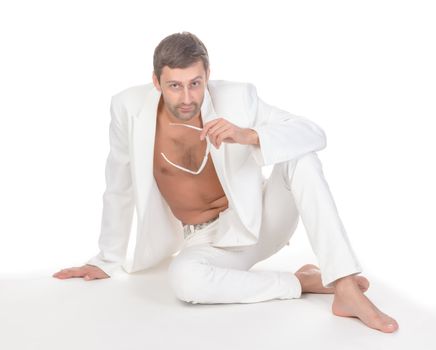 Handsome unbuttoned man in white clothes sitting on white background