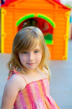 Blond kid girl smiling in outdoor playground with sundress