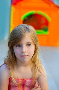 Blond kid girl smiling in outdoor playground with sundress