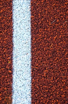 Stadium running track surface closeup background. Interesting textures.