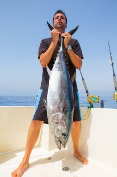 big Bluefin tuna catch by fisherman on boat trolling posing on deck