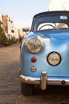 Blue vintage car parked in a paved street