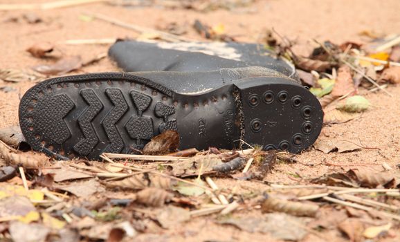 soldier tarpaulin boots in the sand on the beach after high tide