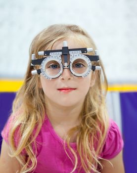 blond children girl with optometrist diopter glasses smiling