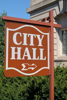 City Hall sign pointing to entrance of a City Hall building.
