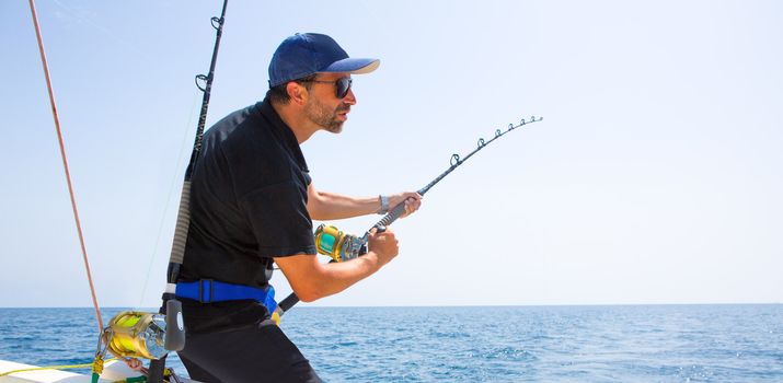 blue sea offshore fishing boat with fisherman holding rod in action