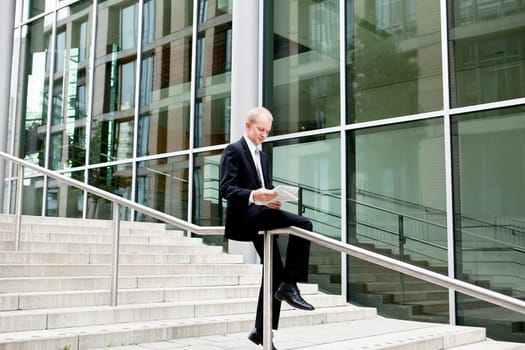 succsessful business man with tie and black dress reading newspaper