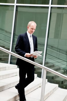 succsessful business man with tie and black dress reading newspaper