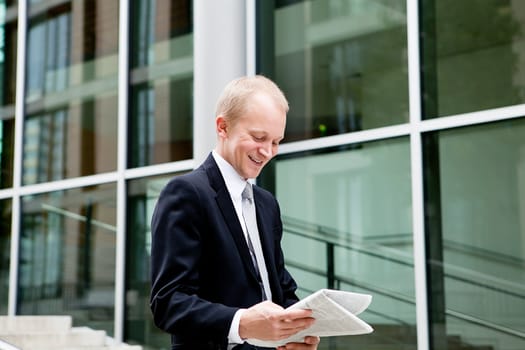 succsessful business man with tie and black dress reading newspaper