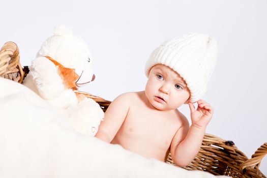 cute little baby infant in basket with white teddy bear