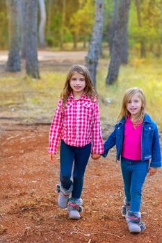 children sister girls walking at the pine forest in autumn