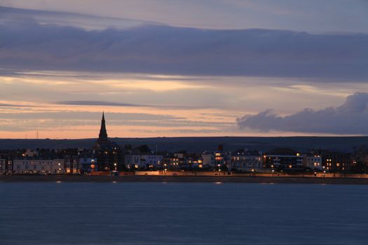 Night sets in  over Weymouth seafront taken from view over the sea