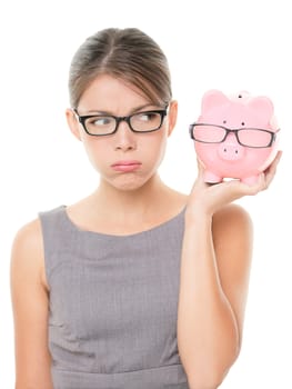 Upset woman wearing glasses holding piggy bank. Expensive eyewear glasses concept. Young female business woman isolated on white background.