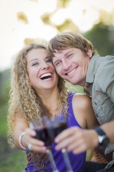 An Attractive Couple Enjoying A Glass Of Wine in the Park Together.