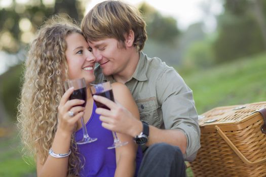 An Attractive Couple Enjoying A Glass Of Wine in the Park Together.