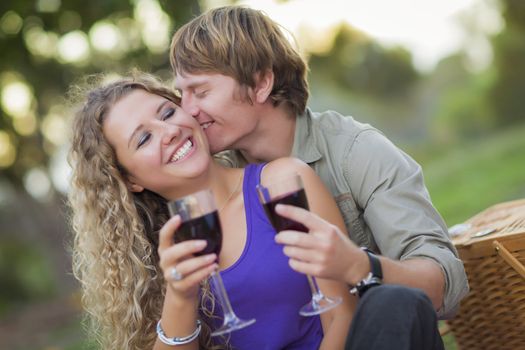 An Attractive Couple Enjoying A Glass Of Wine in the Park Together.