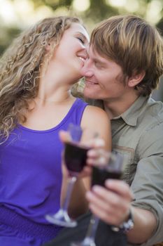 An Attractive Couple Enjoying A Glass Of Wine in the Park Together.