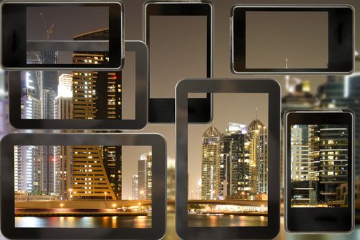 Cellphone and tab with modern buildings in Dubai