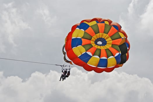 Generic landscape of a pair of female para gliders sailing amongst blue skies and clouds. Location could have been any where but this shot is take in Pachmarhi, Madhya Pradesh, India