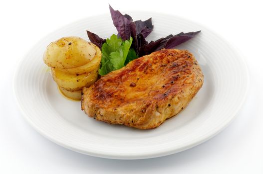 Roast Pork Tenderloin with Greens and Stack of Roasted Potato on White Plate