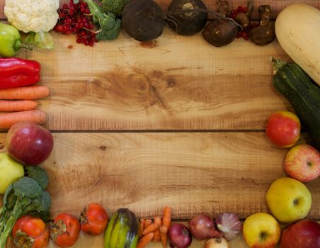 Full Frame of Autumn Harvest with Fruits, Vegetables and Berries closeup on Wood background