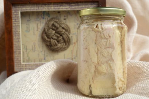 bonito canned in glass jars in nautical background