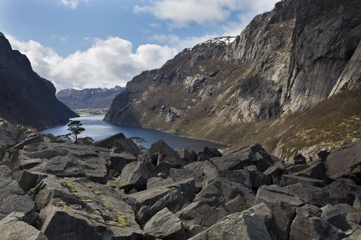 small, deep fjord in norway with scree in foreground