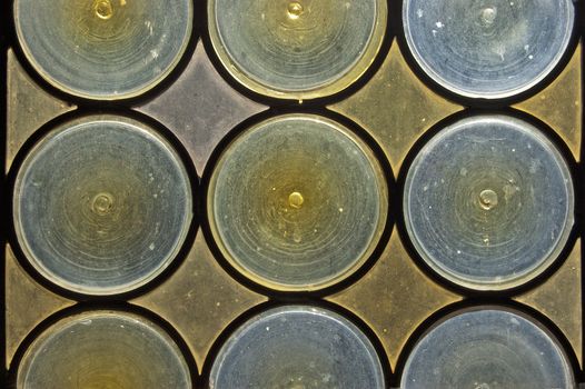 Old window with stained glass - opaque blue and yellow circles
