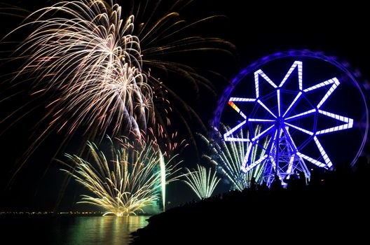 New Year's revelers watch fireworks display by bay, Philippines
