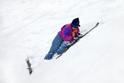 Beginner skier falling on the snow