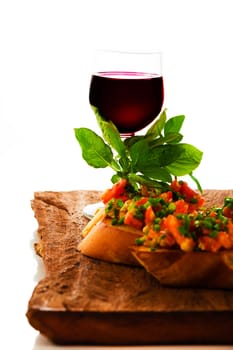 delicious bruschetta appetizer with red wine glass on wooden board