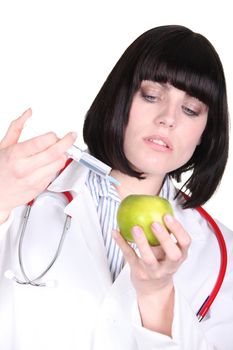 Doctor injecting an apple