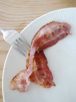 one piece of bacon on a white platter