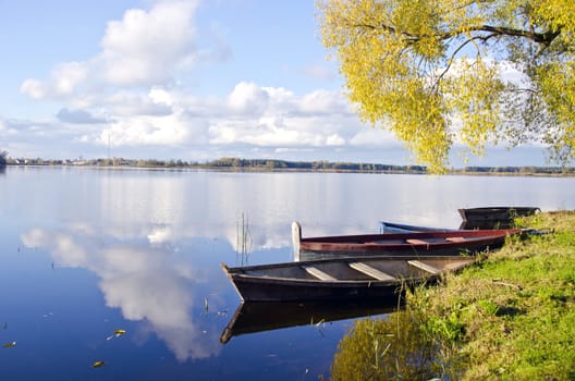 beautiful autumn lake lasndscape with boats and reflections