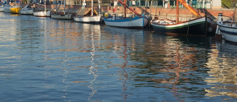 Fishing boats and reflections in Cervia in Italy in the early morning