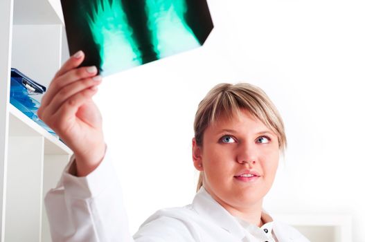 woman doctor looks at x-ray film, smile