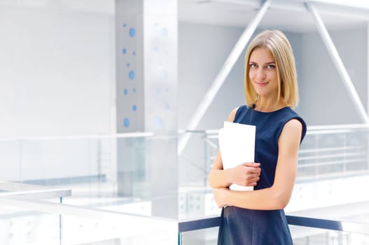 business woman holding reports and looking to the camera, copy space