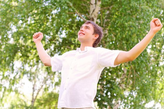 young man looking to the sky, holding his hands up, the expectation of success