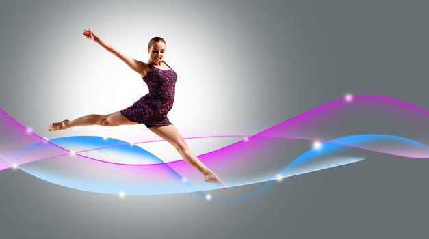 Dancer jumping on the background color rays