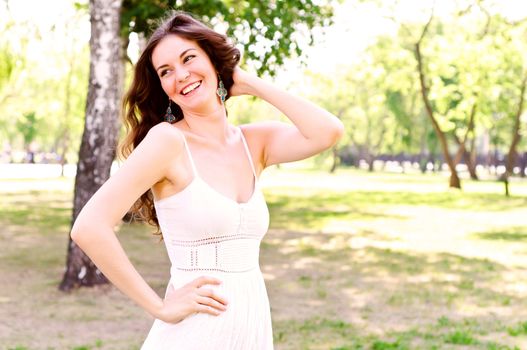 Portrait of an attractive woman in the park, her hair and smiling