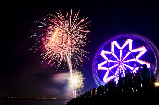 New Year's revelers watch fireworks display by bay, Philippines